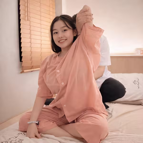 Therapist stretching a client's arm during Thai massage